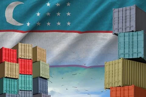 Uzbekistan flag and big stack of shipping cargo containers in docks with sky Stock Photos