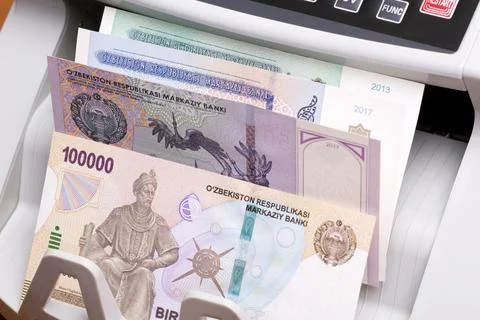 Uzbekistani sum in the counting machine Stock Photos