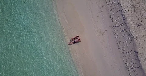 V04022 Aerial flying drone view of Maldives white sandy beach 2 people young Stock Footage