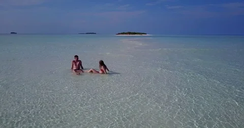 V04029 Aerial flying drone view of Maldives white sandy beach 2 people young Stock Footage