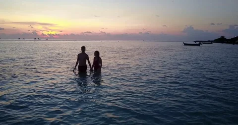 V04153 Aerial flying drone view of Maldives white sandy beach 2 people young Stock Footage