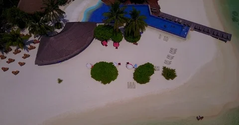 V06698 Aerial flying drone view of Maldives white sandy beach swimming pool in Stock Footage