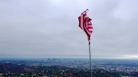 V2-0002 The American flag is blowing in the wind against the blue sky. The A Stock Footage 219297953