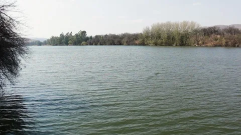 Vaal River Winter landscape Pan with clear sky and calm water small ripples W Stock Footage 113974791