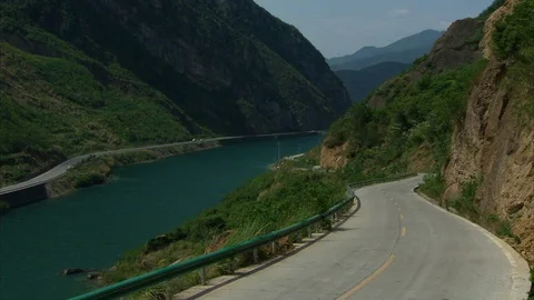 Vacant hillside road and river on a sunny day Stock Footage 88688445