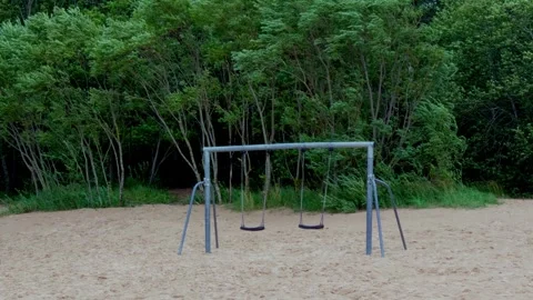 Vacant swing set on sandy beach surrounded by green forest canopy in Jurmala Video stock 344355949