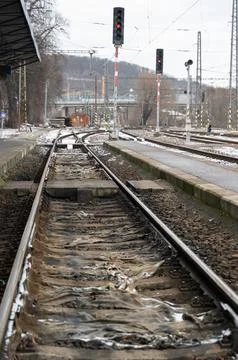 Vacant train terminal under gray overcast with peaceful tracks Stock Photos