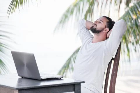 Vacation and technology. Work and travel. Young bearded man using laptop Stock Photos