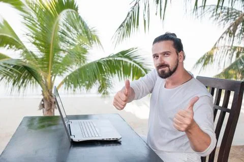 Vacation and technology. Work and travel. Young bearded man using laptop Foto stock