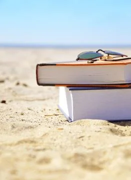 Vacation beach with books in sand Stock Photos