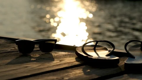 Vacation on the Beach with Flip-Flops and Sunglasses at sunset time Stock Footage 113627897