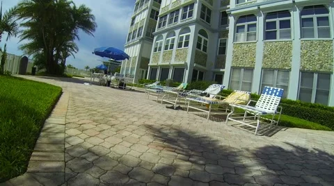 Vacation scene poolside lounge chairs Video stock 40491718