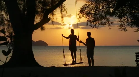 Vacation at sea, the sunset and love on a swing Stock Footage