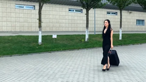 Vacation. Smiling female passenger proceeding to exit gate pulling suitcase Stock Footage 123799305