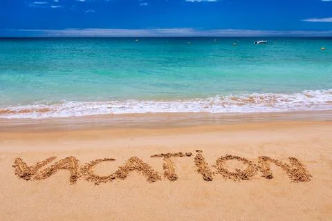 Vacation text on a beach. Vacation written in a sandy tropical beach. "Vaca.. Stock Photos