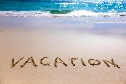 Vacation text on sandy beach Foto stock