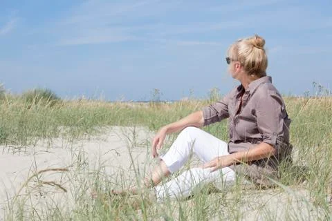 Vacationer sitting on the beach Stock Photos