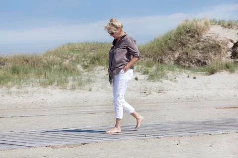 Vacationer walking on beach path Stock Photos