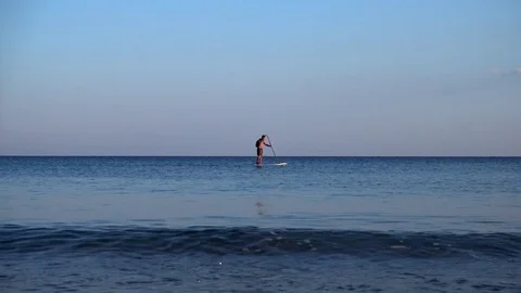 Vacationers go for a drive on a canoe and board in the sea Stock Footage