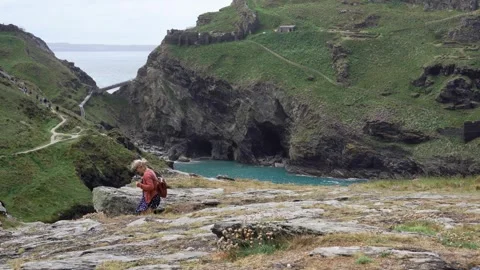 Vacationers walking on cliff path to Tintagel Castle, zoom in Видео 280717397