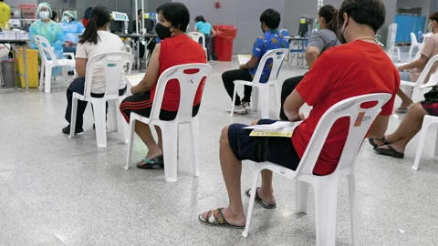 Vaccination center queue of people waiting on chairs Bang Sue Station Bangkok Stock Footage 161807150