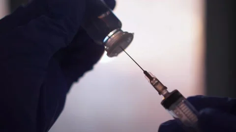 Vaccination concept, someone draw liquid into a syringein. hands with blue glove Video stock 202218747