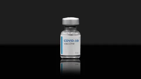 Vaccine bottle on a table on a black background. A dose of Covid-19 vaccine. 動画素材 146242121
