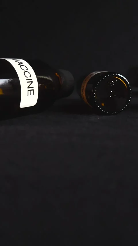 Vaccine bottles lying on a dark background Stock Footage 341326411