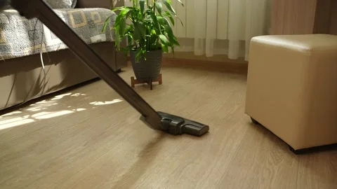 A vacuum cleaner is being used on a light floor in a room featuring bright decor Stock-Footage 308475177