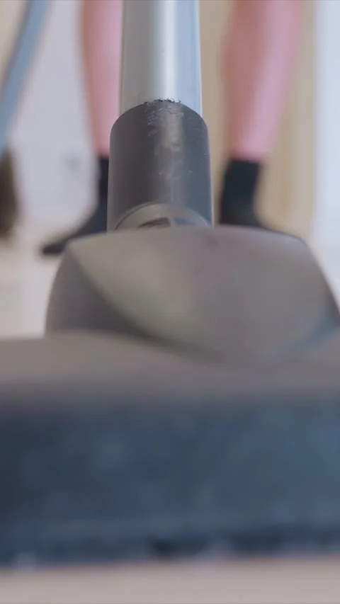 Vacuum Cleaner Head Moves Over Hard Floor With Person Legs in Background showing Stock Footage 346786992