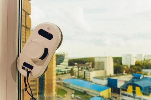 Vacuum cleaner robot cleaning window in high building outdoor. Fotos de archivo