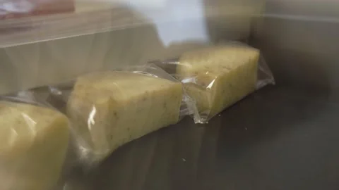 The vacuum machine packs the cheese in plastic packaging, extracting air Stock Footage 143992326