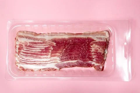 Vacuum-packed bacon on a pink background. A modern way of storing and selling me Stock Photos