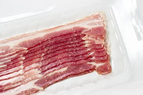 Vacuum-packed bacon on a white background. A modern way of storing and selling m Stock Photos