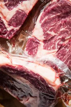 Vacuum packed beef meat steak on wood cutting board Stock Photos