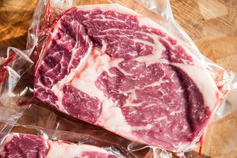 Vacuum packed beef meat steak on wood cutting board Fotos de archivo