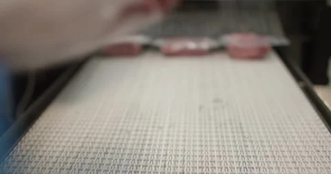 Vacuum packed raw meat moving on conveyor belt in packaging line, Overhead View Video stock 340026446