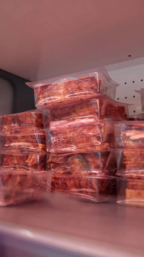 Vacuum packed smoked bacon stacked in refrigerated supermarket display Stock Footage 345978325
