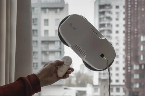 Vacuum robot washes window. Robot assistant at home. Stock Photos