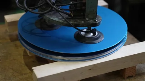 Vacuum suction lifter stacking blue circular steel blanks on wooden pallet Vídeos de archivo 347719923