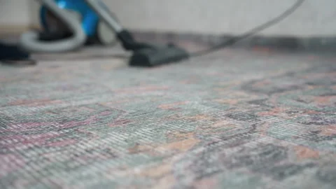 Vacuuming patterned rug. Home carpet cleaning in natural light. Carefully Stock Footage 337455439