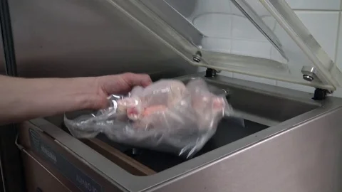 A vacuuming process - a man takes a vacuum-packed poultry out of a machine Stock Footage 82682194