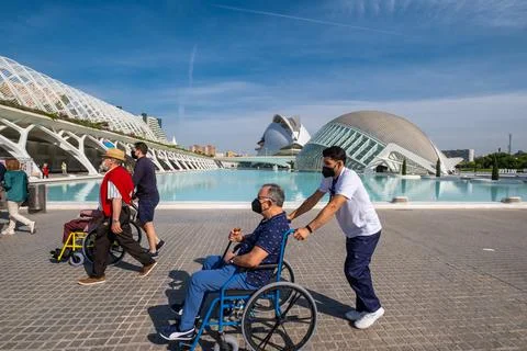 VALENCIA, SPAIN - May 21, 2021: People walking through Valencia in wheelchair Stock Photos