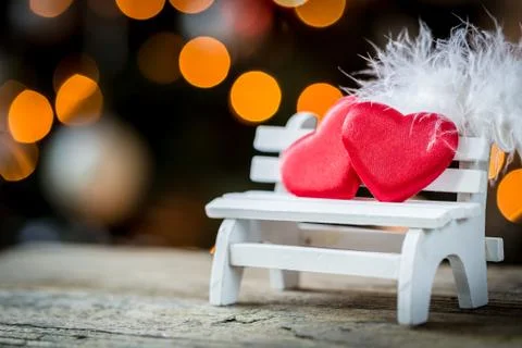 Valentine heart and feather on a wooden bench Stock Photos