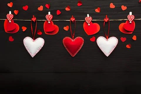 Valentine hearts hanging on string with red and white decor Stock Photos