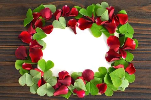 Valentines Day background with frame of red rose petals and heart shaped leav Foto stock
