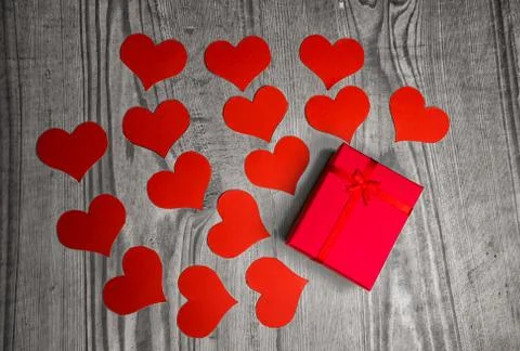 Valentines day background with handmaded paper hearts and gift over old wood. Stock Photos