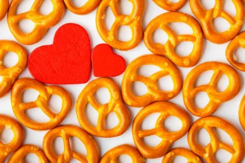 Valentine's day background pretzels pattern and red heart. Stock Photos