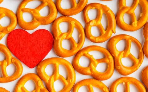 Valentine's day background pretzels pattern and red heart. Stock Photos