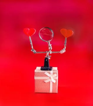 Valentines Day background with tool third hand holding hearts and gift on red Foto stock